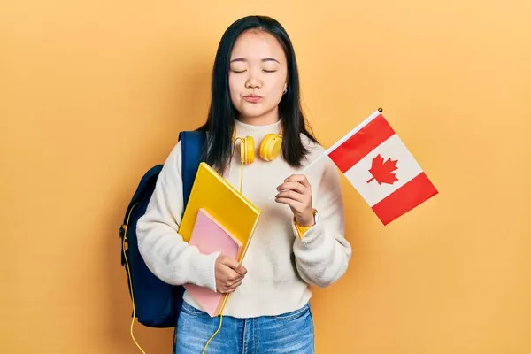 Νεαρή Κινέζα Φοιτήτρια Ανταλλαγής Κοριτσιών Που Κρατάει Καναδική Σημαία Κοιτάζοντας — Φωτογραφία Αρχείου