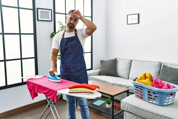 Ung Latinamerikansk Man Olycklig Strykning Kläder Hemma — Stockfoto