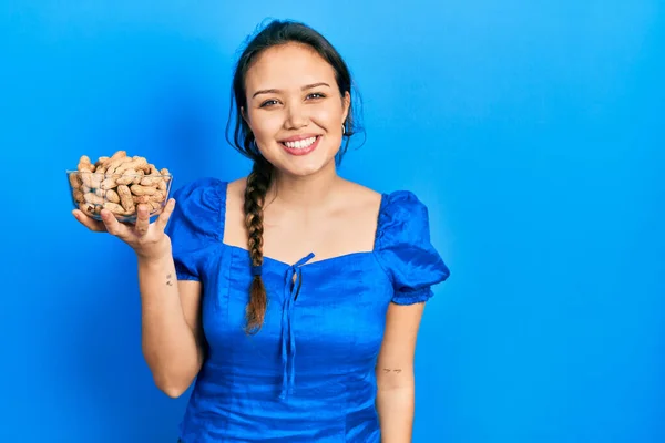 Joven Chica Hispana Sosteniendo Tazón Cacahuetes Luciendo Positiva Feliz Pie —  Fotos de Stock