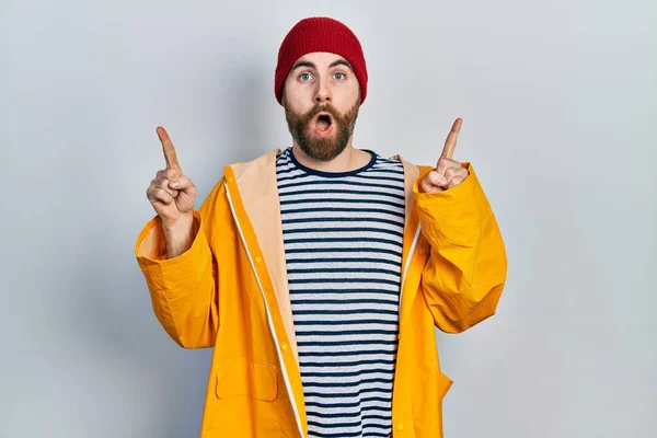 Hombre Caucásico Con Barba Vistiendo Impermeable Amarillo Asombrado Sorprendido Mirando —  Fotos de Stock