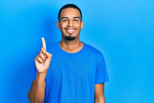 Молодий Афроамериканець Звичайній Блакитній Футболці Показує Вказує Пальцем Номер Один — стокове фото
