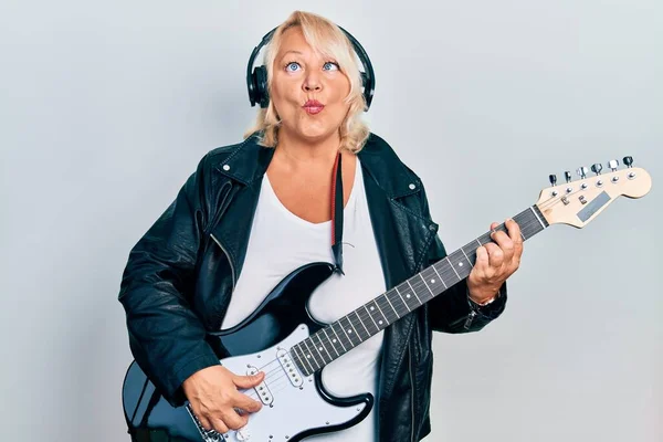 Orta Yaşlı Sarışın Kadın Elektronik Gitar Çalıyor Kulaklık Takıyor Ağzıyla — Stok fotoğraf