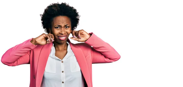 アフリカ系アメリカ人の女性は ビジネスジャケットを着用し 大きな音楽のノイズに悩まされた表情で指で耳をカバーしています 聴覚障害の概念 — ストック写真