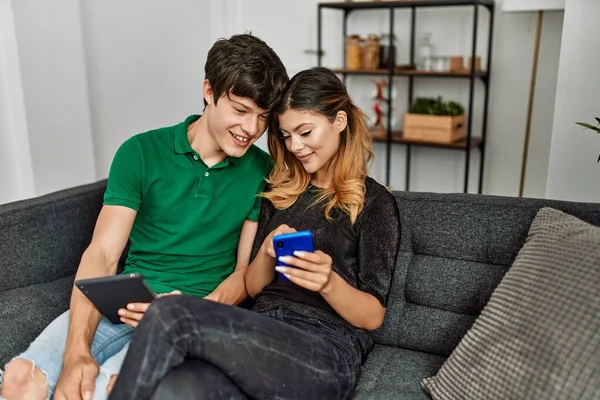 Jovem Casal Caucasiano Sorrindo Feliz Usando Touchpad Smartphone Casa — Fotografia de Stock