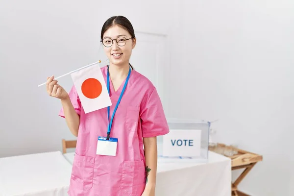 유세를하고 아시아인 간호사가 긍정적 행복해 보이는 국기를 — 스톡 사진