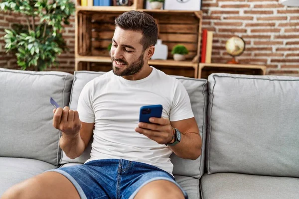 Young Hispanic Man Smiling Confident Using Smartphone Credit Card Home — Stockfoto