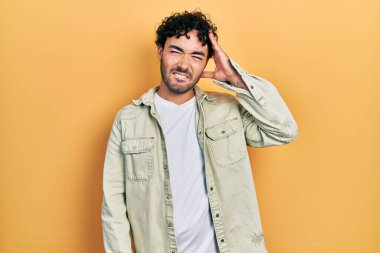 Gündelik kıyafetler giyen genç İspanyol adam soru sorup kafasını karıştırıyor. Şüpheyle kararsız, kafa kafaya düşünerek. Düşünceli kavram. 