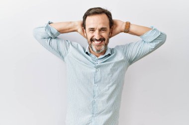 Orta yaşlı, sakallı, izole edilmiş arka planda duran kolları ve elleri başının arkasında mutlu bir şekilde gülümseyen, esneyen İspanyol bir adam. 