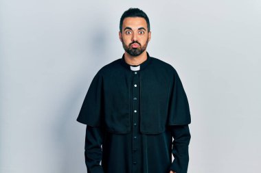 Sakallı, Katolik rahip cübbesi giyen, komik suratlı yakışıklı İspanyol bir adam. Havayla şişmiş ağız, çılgın bir ifade.. 