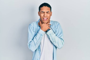 Genç Afro-Amerikan adam günlük kıyafetler giyip bağırıyor ve boğuluyor çünkü acı verici bir boğulma var. Sağlık problemi. Boğulma ve intihar konsepti. 