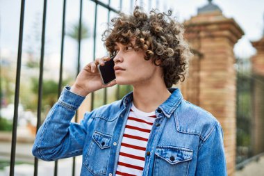 Genç İspanyol adam şehirde telefonla konuşuyor.