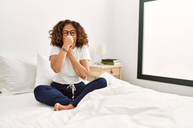 Orta yaşlı İspanyol bir kadın evde yatağında oturmuş pis ve iğrenç bir koku alıyor. Nefesini burnunda tutuyor. Kötü kokuyor. 