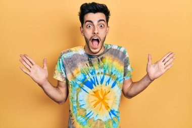 Sıradan kıyafetler giyen genç İspanyol adam çılgın ve başarıyı kollarını kaldırıp heyecanla haykırarak kutluyor. Kazanan konsept 