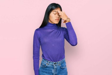 Güzel, genç Asyalı kadın gündelik kıyafetler giyip yorgun burnu ve gözleri ovuşturup yorgun ve baş ağrısı çekiyor. Stres ve hüsran kavramı. 