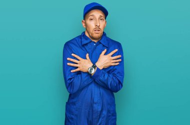 Kel ve sakallı bir adam. Üniforma giyiyor. Kış soğuğu yüzünden titriyor ve donuyor. 