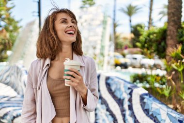 Beyaz kız gülümsüyor, şehirde kahve içiyor..