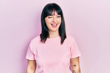 Gündelik kıyafetler giyen genç İspanyol kadın kameraya seksi bir ifadeyle bakıyor, neşeli ve mutlu bir yüzle.. 