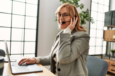 Ofiste çalışan orta yaş çağrı merkezi ajanı..