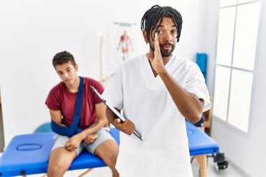 Ağzı kırık bir adamla birlikte ağrı kesici kliniğinde çalışan genç İspanyol bir adam gizli söylentiler yayıyor, kötü niyetli konuşmalar fısıldıyor. 