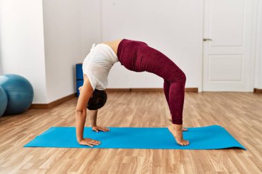 Genç İspanyol kadın spor merkezinde yoga eğitimi alıyor.