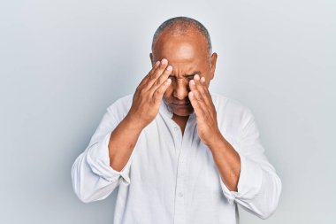 Stres yüzünden başı ağrıyan orta yaşlı, günlük kıyafetler giyen Latin bir adam. migren ağrısı. 
