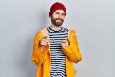 Sakallı, sarı yağmurluk giyen, mutlu ve komik yüzlü beyaz bir adam. iyi enerji ve titreşimler. 