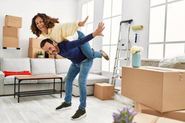 Yeni evinde kadını sırtında taşıyan bir adam.