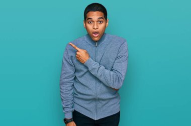 Gündelik eşofman giyen genç, yakışıklı İspanyol adam parmaklarını yana çevirerek şaşırdı, ağzı açık hayret içinde kaldı.. 