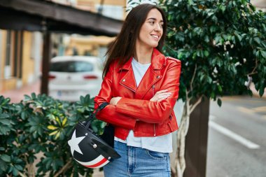 Genç İspanyol kadın gülümsüyor şehire moto miğferi tutarken mutlu.