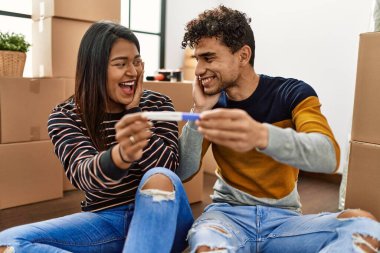 Genç Latin çift yeni evlerinde yerde otururken hamilelik testi yaparken şaşırdılar..