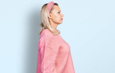 Kafkasyalı genç bir kadın günlük giysiler giyiyor, rahat bir görünüm takınıyor, doğal bir yüz ifadesi ve kendine güvenen bir gülümsemeyle poz veriyor.. 