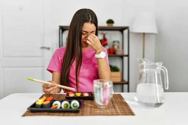 Mujer Morena Joven Comiendo Sushi Usando Palillos Cansados Frotando Nariz — Foto de Stock