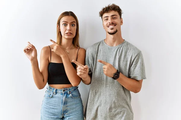 Jong Mooi Paar Staan Samen Geïsoleerde Achtergrond Wijzen Opzij Bezorgd — Stockfoto