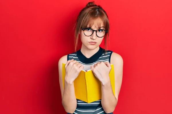 Redhead Young Woman Reading Book Wearing Glasses Skeptic Nervous Frowning — Stockfoto