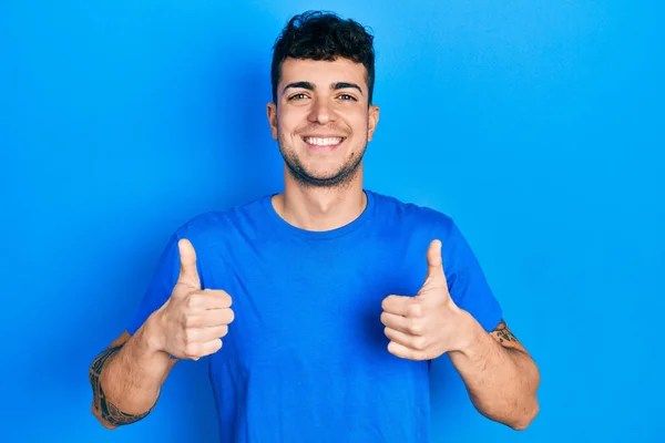 Joven Hombre Hispano Vistiendo Casual Camiseta Azul Signo Éxito Haciendo — Foto de Stock