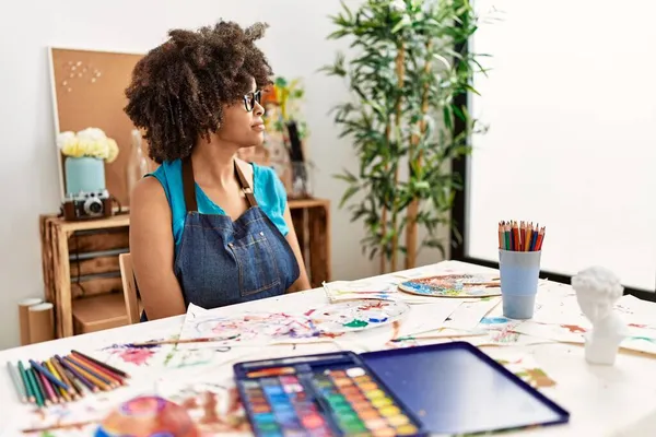 美丽的非洲裔美国女人 在艺术工作室里画着非洲式的头发 向侧面看 带着自信的微笑放松自己的姿态 — 图库照片