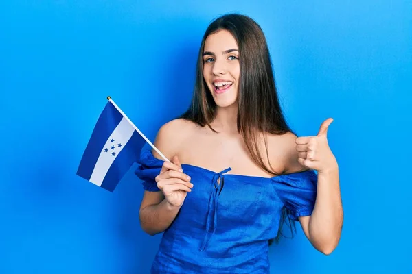 Young Brunette Teenager Holding Honduras Flag Smiling Happy Positive Thumb — Stockfoto