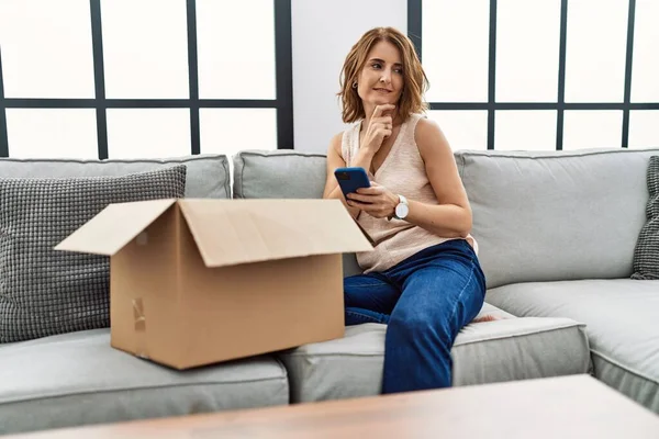 Middle Age Woman Sitting Sofa Checking Delivery Package Phone Serious — Fotografia de Stock