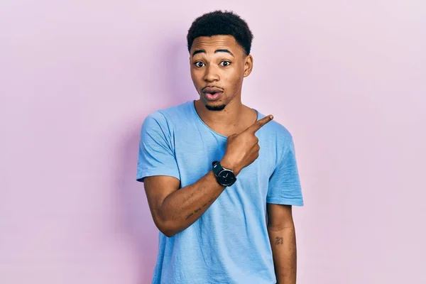 Young African American Man Wearing Casual Blue Shirt Surprised Pointing — Stock fotografie