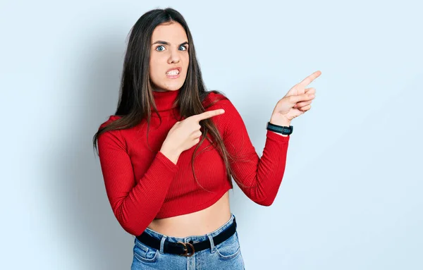 Young Brunette Teenager Wearing Red Turtleneck Sweater Pointing Aside Worried — Stockfoto