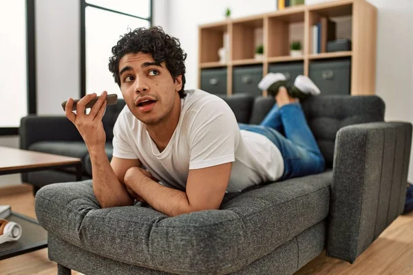 Ung Latinamerikansk Man Pratar Smartphone Liggande Soffan Hemma — Stockfoto