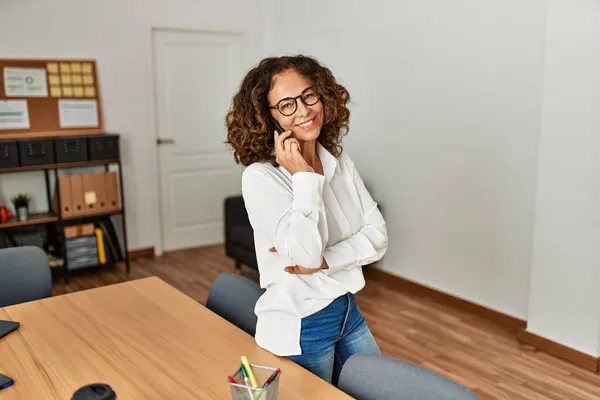 Mujer Hispana Mediana Edad Sonriendo Confiada Hablando Teléfono Inteligente Oficina —  Fotos de Stock