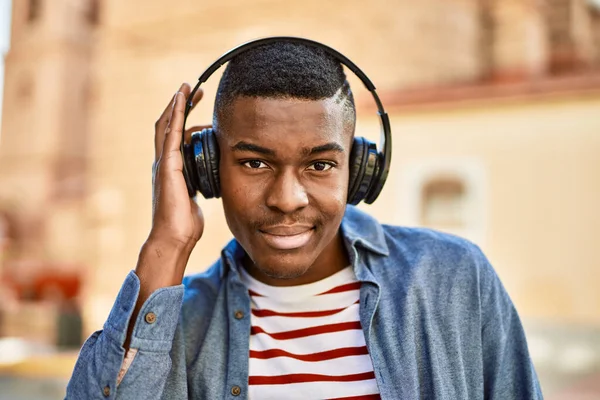 Młody Afrykanin Uśmiecha Się Szczęśliwy Używając Słuchawek Mieście — Zdjęcie stockowe