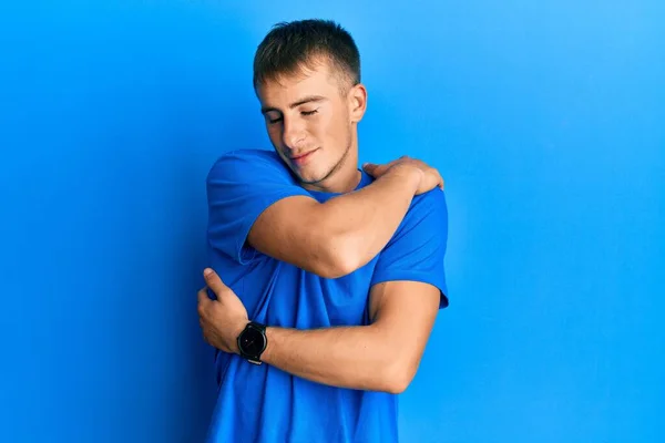 年轻的高加索人穿着休闲的蓝色T恤 拥抱自己快乐而积极 充满自信的微笑 自爱和自我照顾 — 图库照片