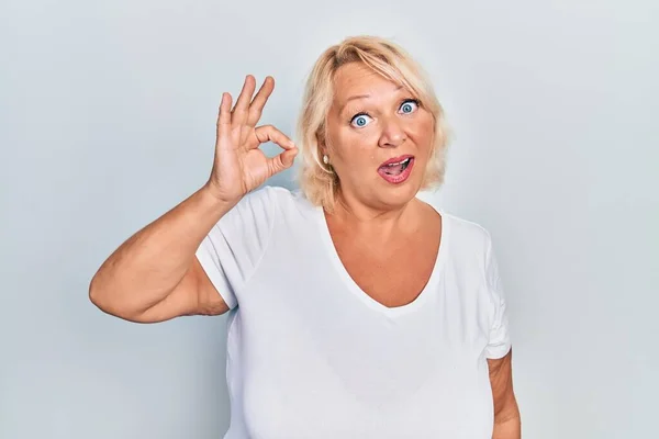 Medelålders Blond Kvinna Gör Positiv Gest Chock Ansikte Ser Skeptisk — Stockfoto