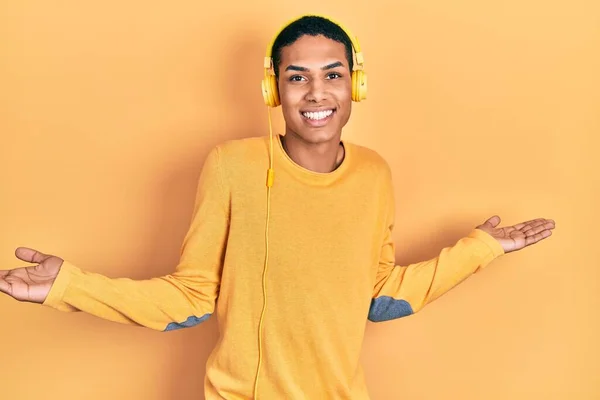 Joven Chico Afroamericano Escuchando Música Usando Auriculares Sonriendo Mostrando Ambas —  Fotos de Stock