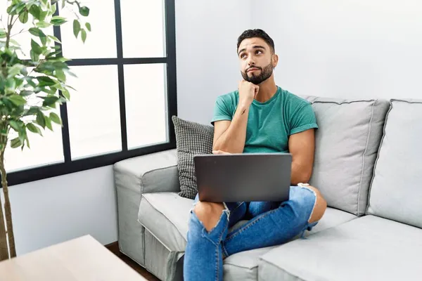 Jovem Homem Bonito Com Barba Usando Computador Portátil Sentado Sofá — Fotografia de Stock