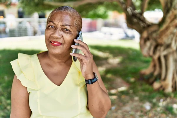 非洲裔美国老妇人坐在公园的长椅上 用智能手机交谈 — 图库照片