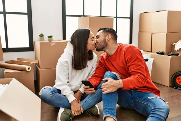 Young Latin Couple Kissing Using Smartphone New Home — Stock Photo, Image