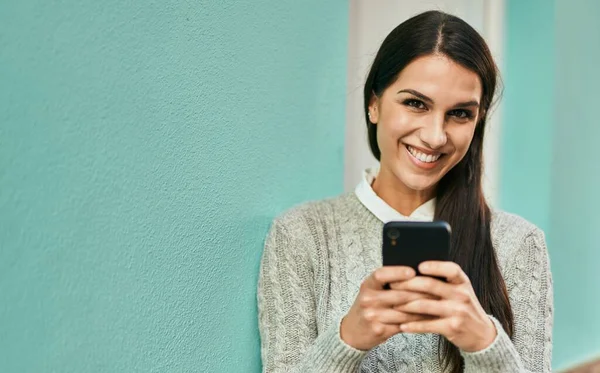 若いヒスパニック系の女性は 市内でスマートフォンを使用して幸せな笑顔 — ストック写真